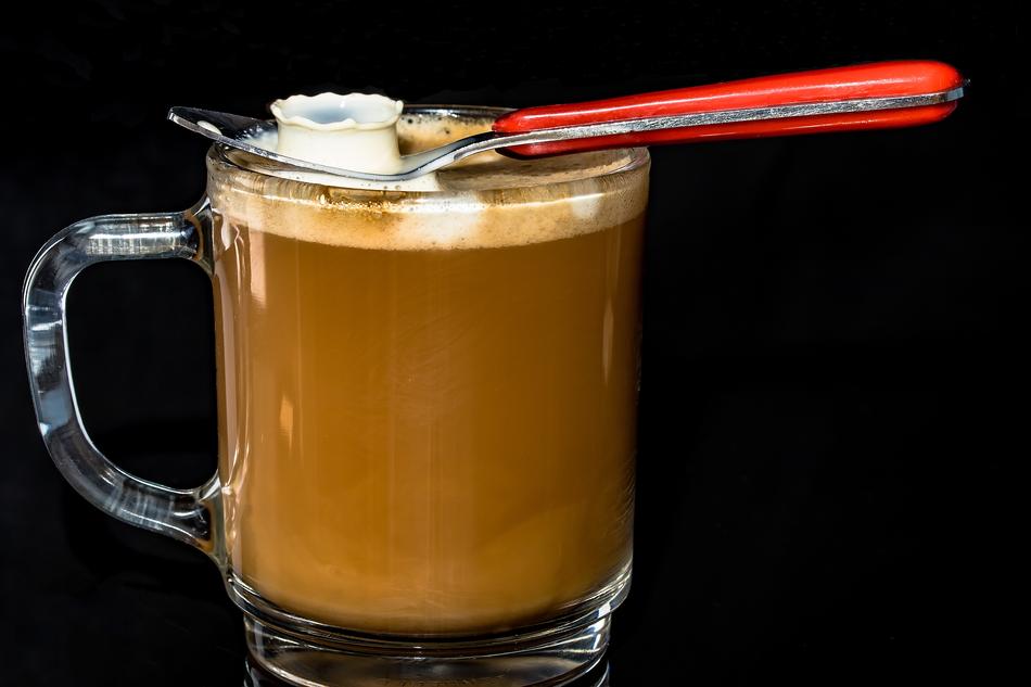 Beautiful glass coffee with milk and sugar and a spoon on it