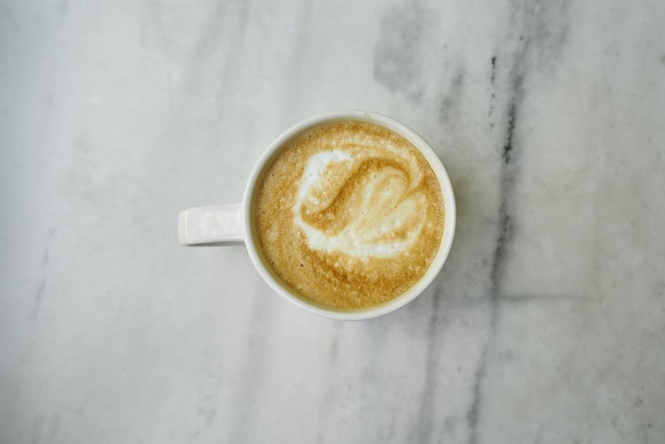 white cup with latte on the table