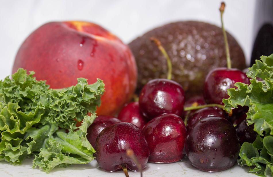 Beautiful and colorful peach and cherries, near the other fruits and greenery