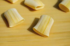 Beautiful Paccheri Giganti, on the brown and yellow, wooden surface