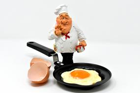 Fried egg Cooking, funny cook figurine near pan