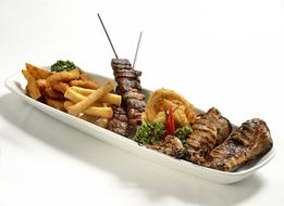 Barbecue with French fries in a long white plate