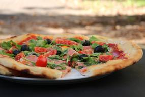 Pizza with ham and tomatoes close up