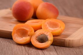 ripe apricots on a wooden cutting board