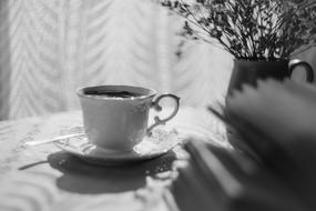 cup with coffee on the table in black and white blurred background