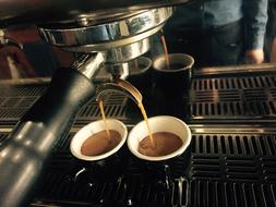 Making beautiful, brown Espresso coffee in the cups, with the machine