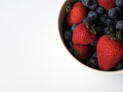 Colorful and beautiful, strawberries and blueberries in the bowl, on the white surface
