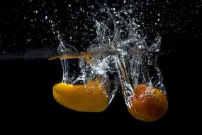 yellow pepper in water on black