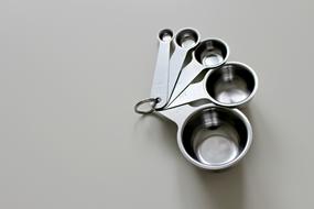Close-up of the metal measuring cup, on the table