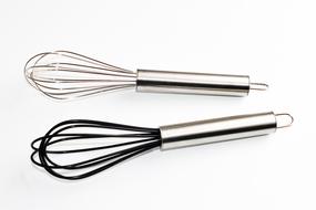 Shiny, colorful whisks, with the metallic handles, at white background