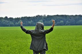 free happy man in the middle of a green field