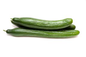 Three ripe, green cucumbers, on the white surface