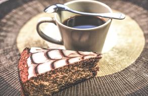 Cup of coffee, with the spoon, and beautiful and colorful cake