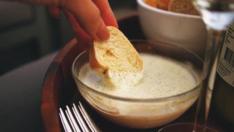 dipping bread in aioli sauce