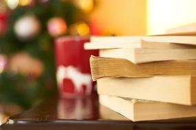 stack of books and christmas candle on the table