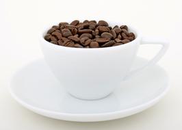 fragrant coffee beans in a white cup on a saucer