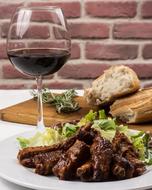 Beautiful, served pork ribs, with the bread, herbs and glass of wine