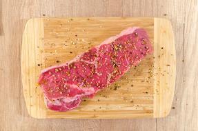 beef stack with spices on a wooden cutting board