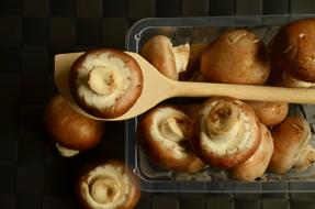 brown mushrooms, wooden spoon and baking sheet