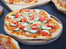 pizza with vegetables on wooden boards