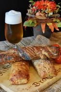 pastries on a wooden board on a table next to a glass of beer