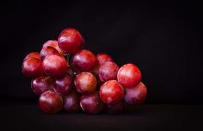 red grapes on black background