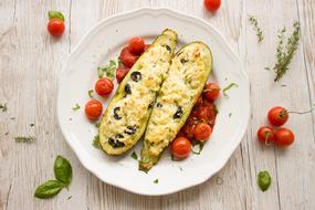 stuffed baked zucchini with tomatoes on a plate