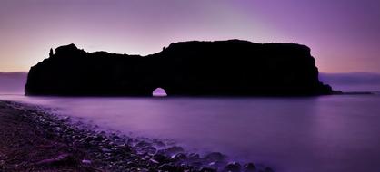 Beautiful landscape with the rock with the hole in the wall, in the Coffee Bay in South Africa, at colorful and beautiful sunset in the sky