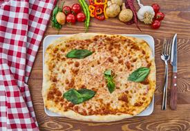 tomato pizza with green basil leaves