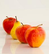 colorful apples and pears in a row on white