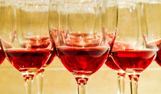 Shiny glasses with beautiful red wine, in light, on the Christmas Party