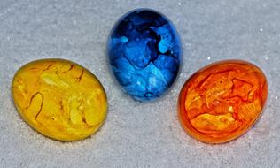 Close-up of the beautiful and colorful, shiny Easter Eggs on the shiny snow