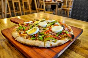 Colorful and beautiful pizza on the wooden board, on the wooden table