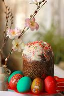 Beautiful and colorful Easter still life with the Easter cake, Easter Eggs and plant with flowers in the pot