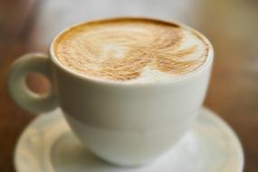 Beautiful, brown and white coffee in the cup on the saucer
