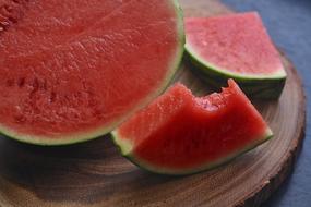 sliced ripe watermelon on a wooden cutting board close up