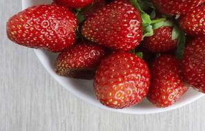 red ripe strawberries in a white plate close-up