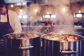 steam over pots of soups in a restaurant