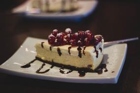 Beautiful and colorful cheesecake pieces with berries and sauce, on the plates