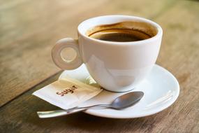 coffee in a white cup on a wooden table close up