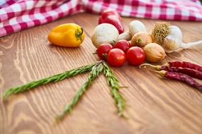 Vegetables and herbs on wooden table, background