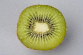 Close-up of the cut, of the beautiful and colorful kiwi, on the white surface