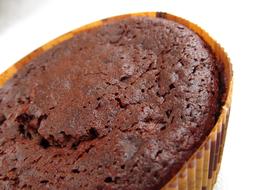 Close-up of the beautiful, brown chocolate cupcake with orange cover, in light