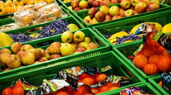 Colorful fruits in the green boxes, in the supermarket