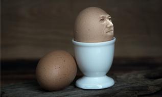 Egg with face, in the white egg cup, near the other shiny egg, clipart