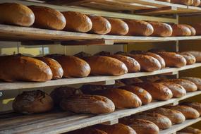Close-up of the wooden shelves with the loaves of bread, in light