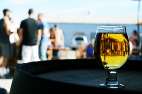 a glass of beer on a barrel on the street