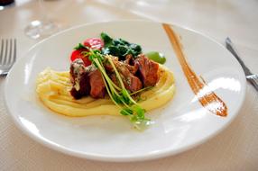 Colorful meal with mashed potatoes and vegetables, on the plate among the cutlery