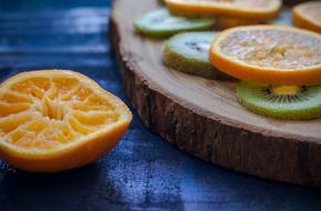 Orange Kiwi sliced on Wood