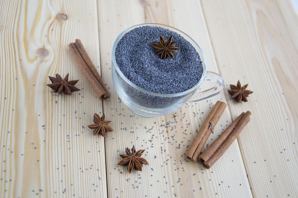 poppy seeds in a transparent cup and cinnamon on the table